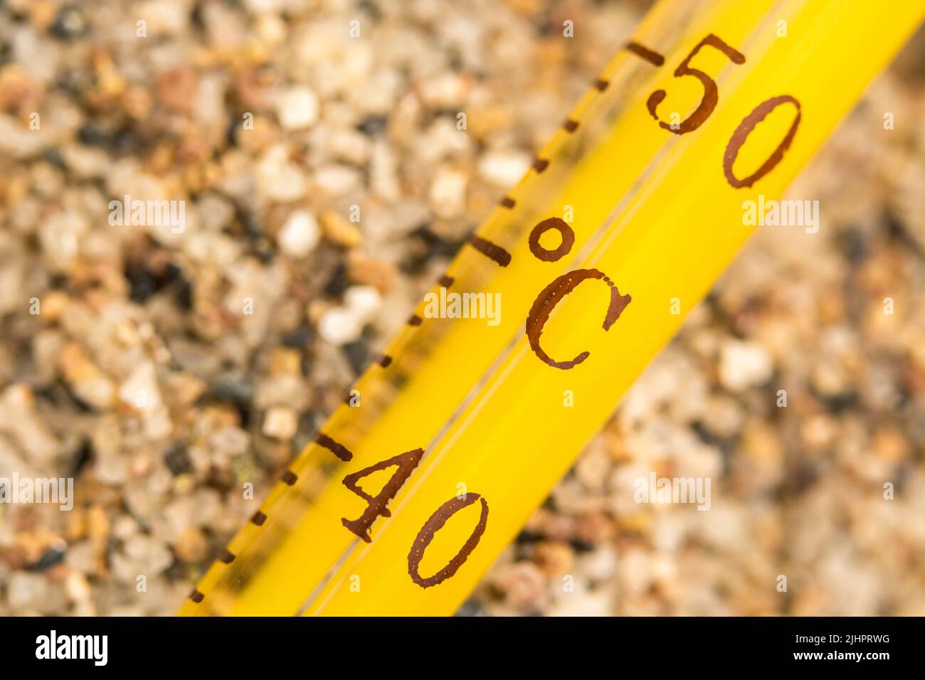 Close-up glass alcohol thermometer on coarse sand, showing 40-50 C. For 2023 Summer heatwave, UK heatwave, hot weather, high temperatures, severe heat Stock Photo