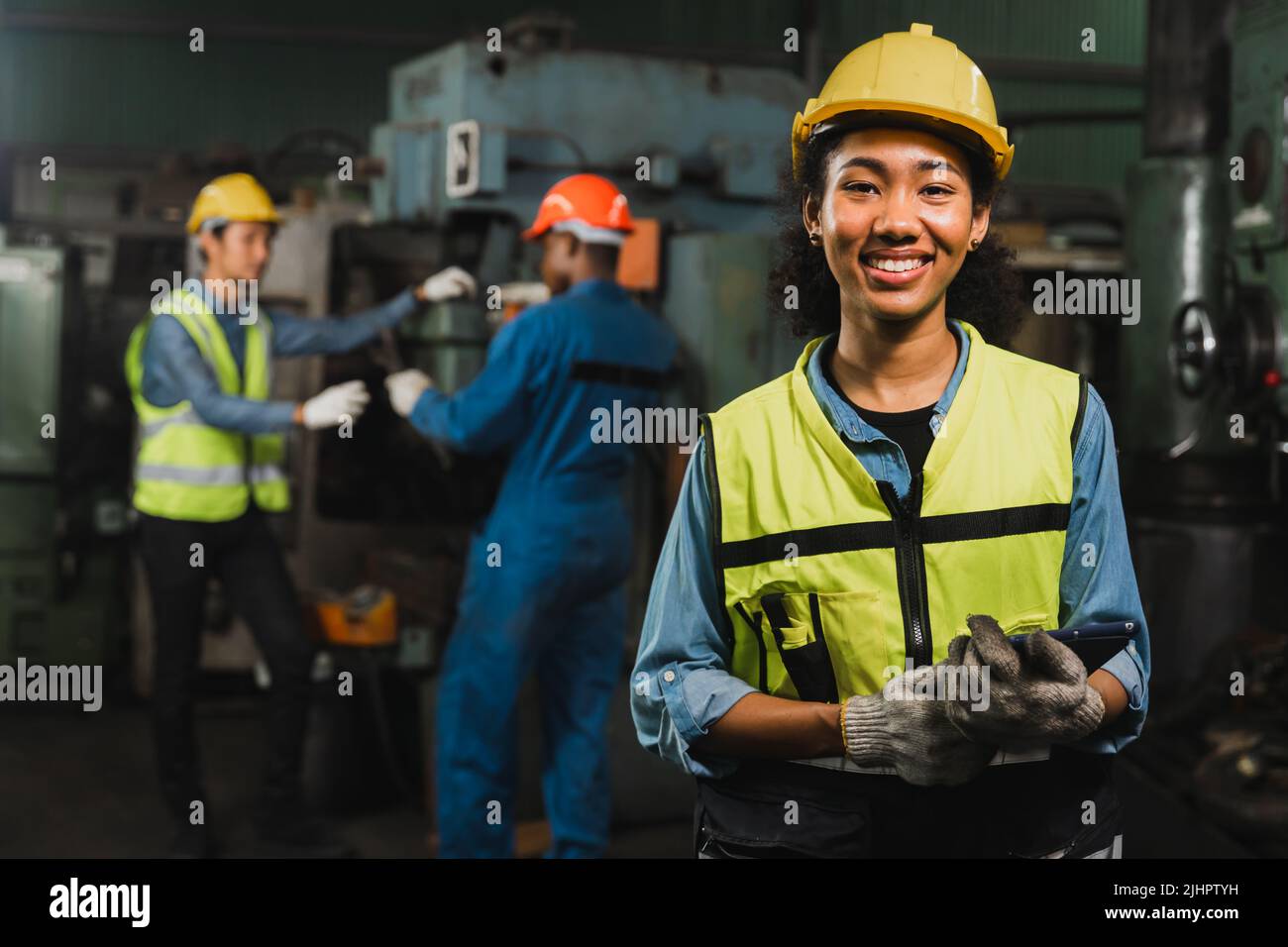 Engineer woman holding tablet and smile in factory industry working hard concept Stock Photo