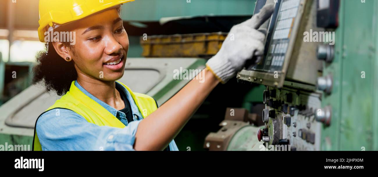engineer industry African young woman worker working and check on machine in factory Stock Photo