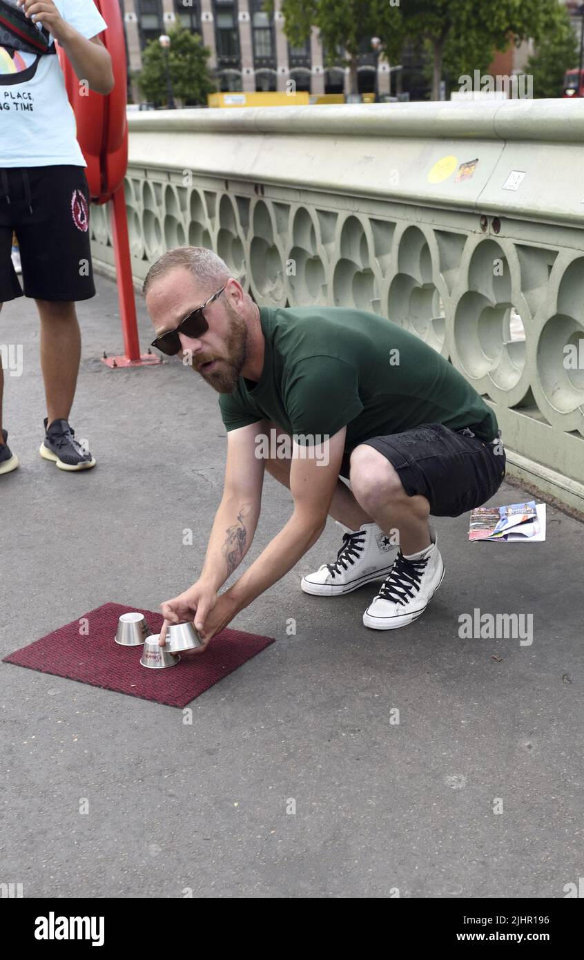 The Shell Game / Three Cups Trick - illegal scam on Westminster Bridge, London, England, UK. Stock Photo