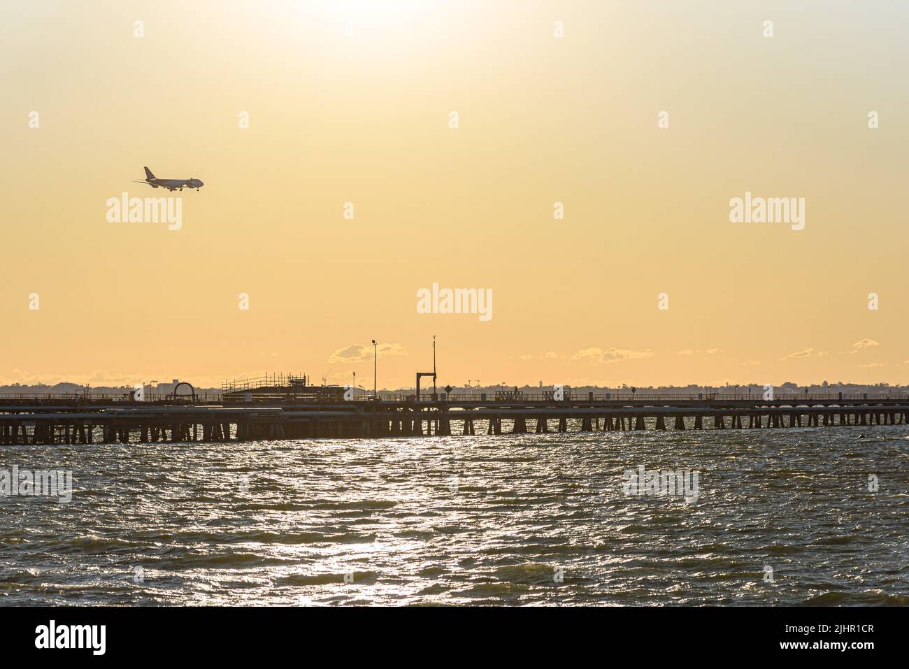 A UPS 747 plane on its approach to Sydney Airport above Botany Bay at sunset Stock Photo