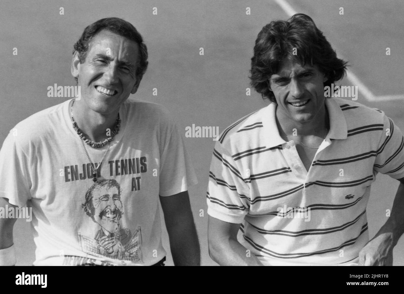 French photographer André Crudo and sports journalist Gérard Holtz, posing on a tennis court between two matches of the French Open. Paris, Roland-Garros stadium, May, 1982 Stock Photo