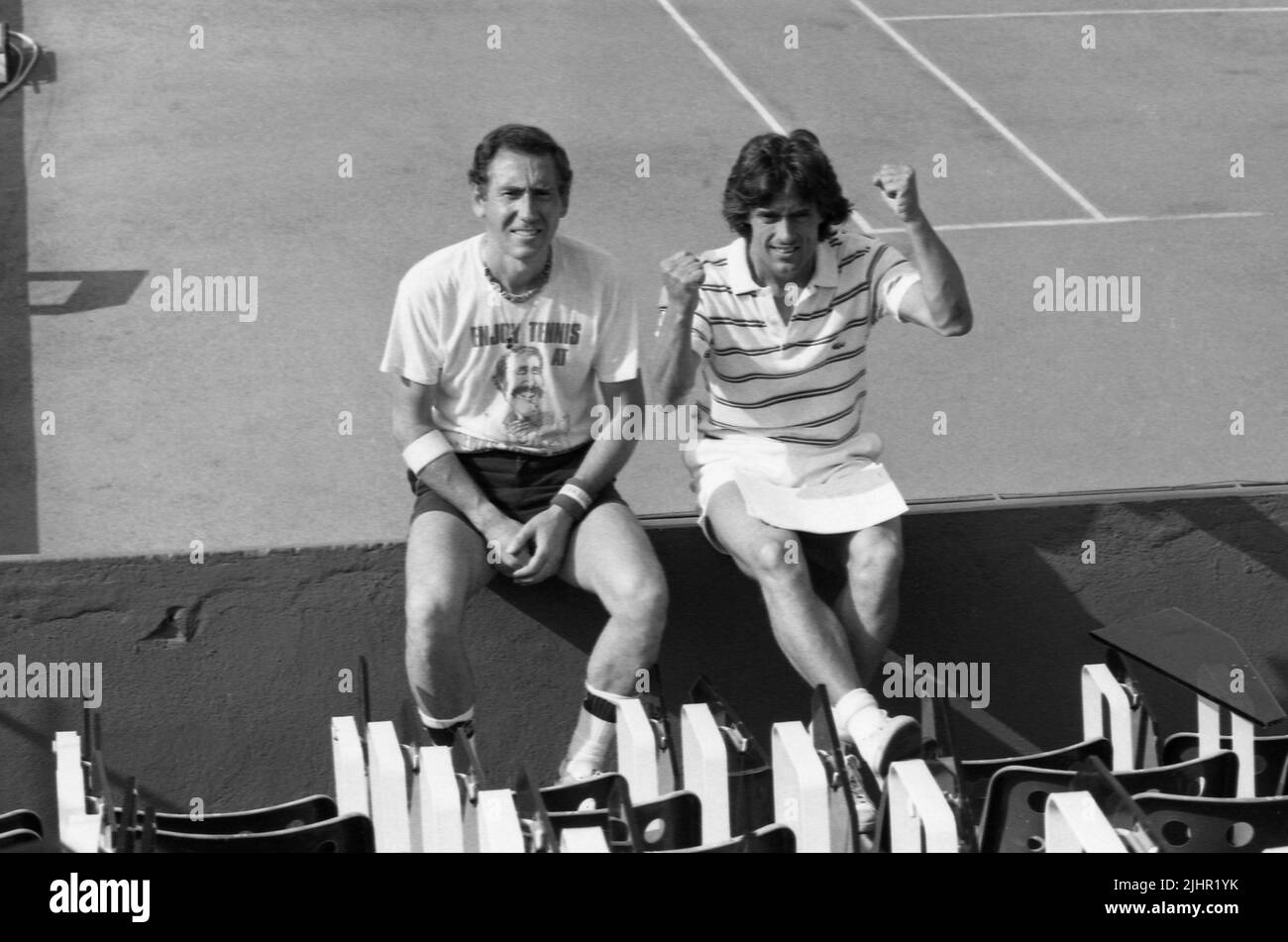 French photographer André Crudo and sports journalist Gérard Holtz, posing on a tennis court between two matches of the French Open. Paris, Roland-Garros stadium, May, 1982 Stock Photo