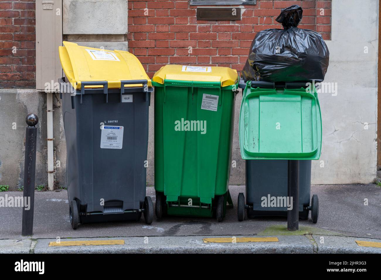 France, Ile de France region, Paris, 4th rue Chanoinesse, green and yellow dustbins (for cardboard and glass), Stock Photo