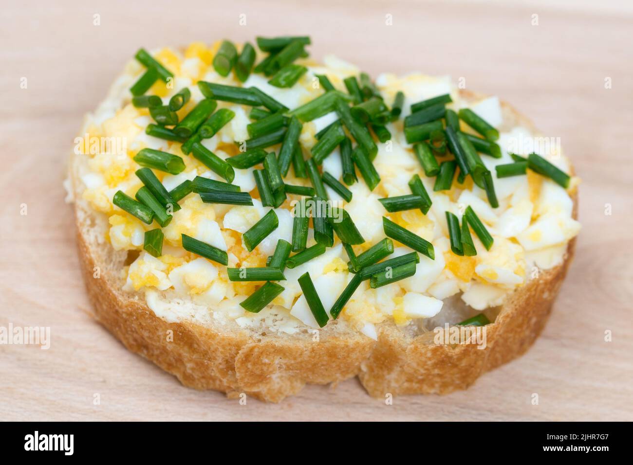 small open sandwich with boiled egg and chives selective focus  on wooden board selective focus Stock Photo