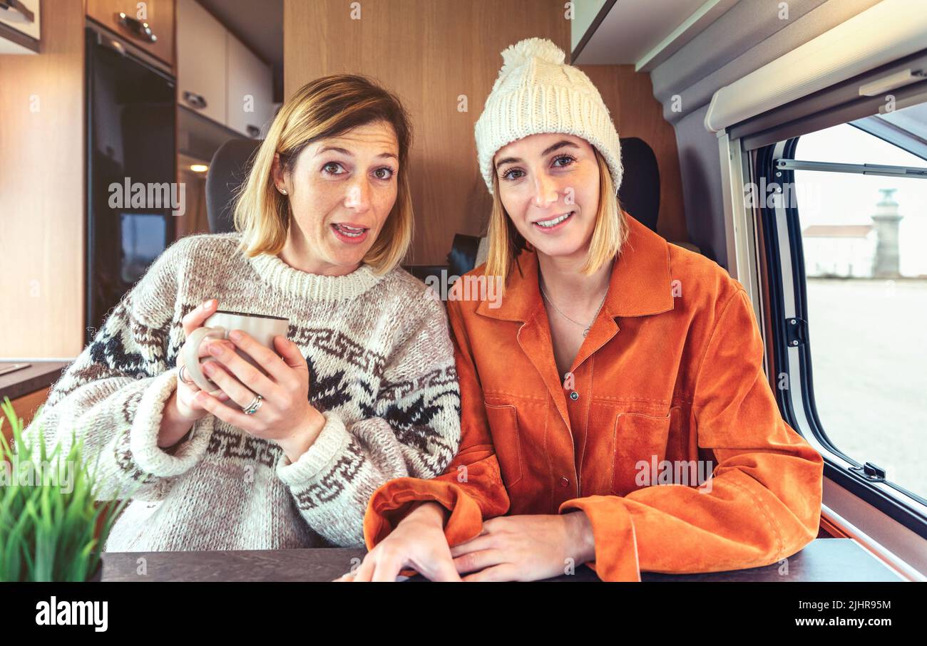 Women talking looking at camera on videoconference from their campervan Stock Photo