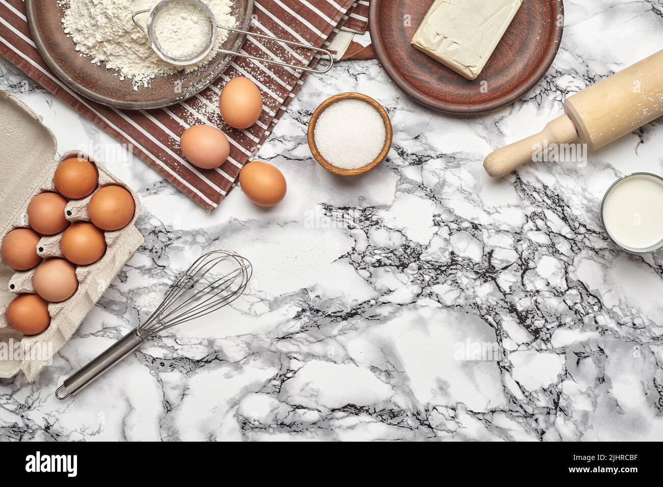 Close-up shot. Top view of a baking ingredients and kitchenware on the marble table background. Stock Photo