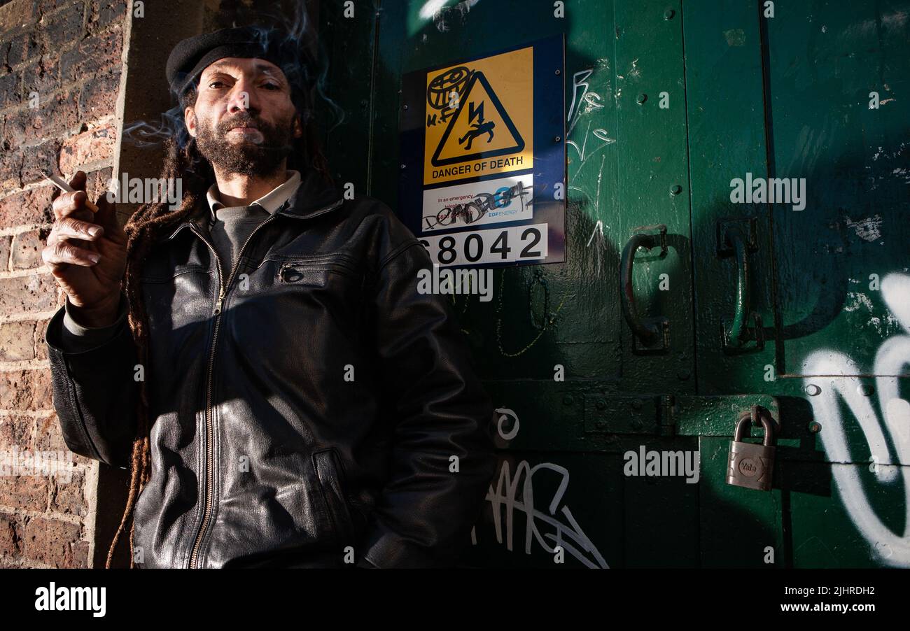 Street Life; Pride. A homeless character smoking a cigarette in a London back street. From a series with the same model. Stock Photo