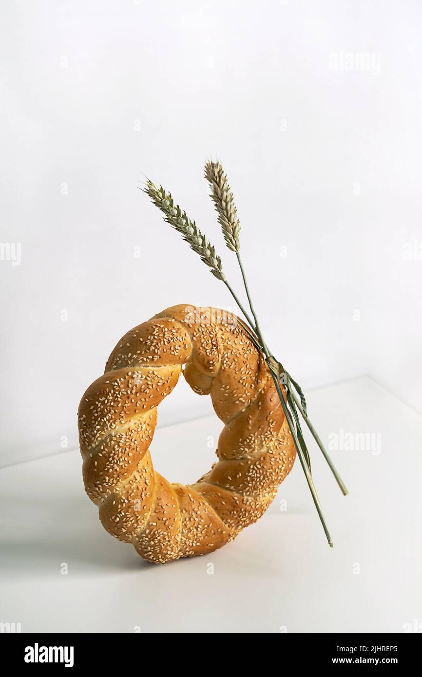 Fresh bread loaf on white table. Baked bread and ears of wheat still ...