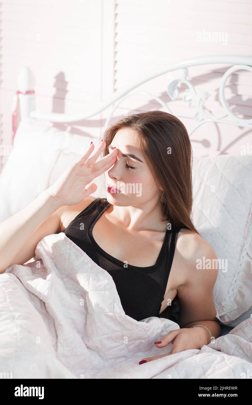 Young woman in bed with headache portrait Stock Photo Alamy