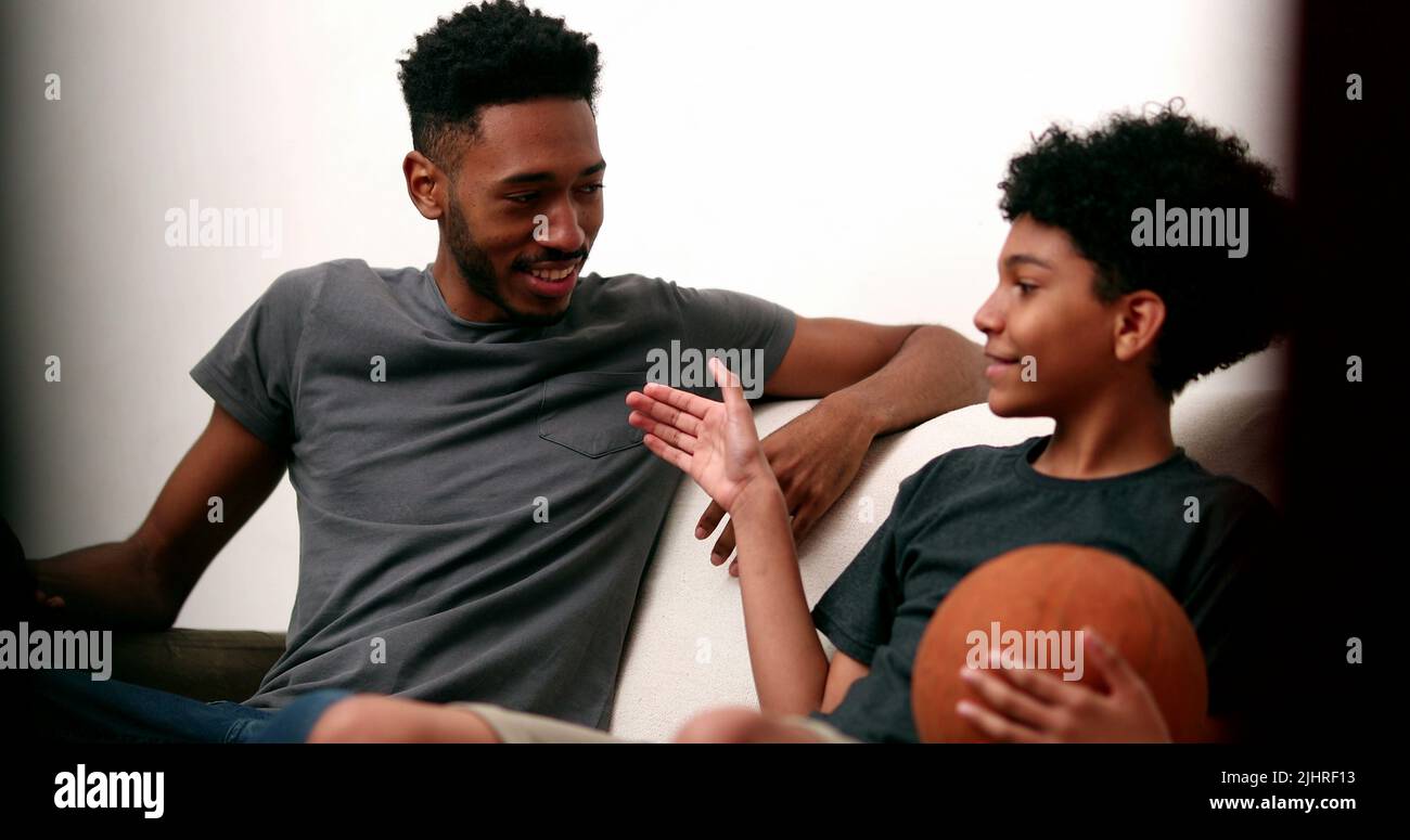 Older brother teaching younger sibling to spin basketball with finger