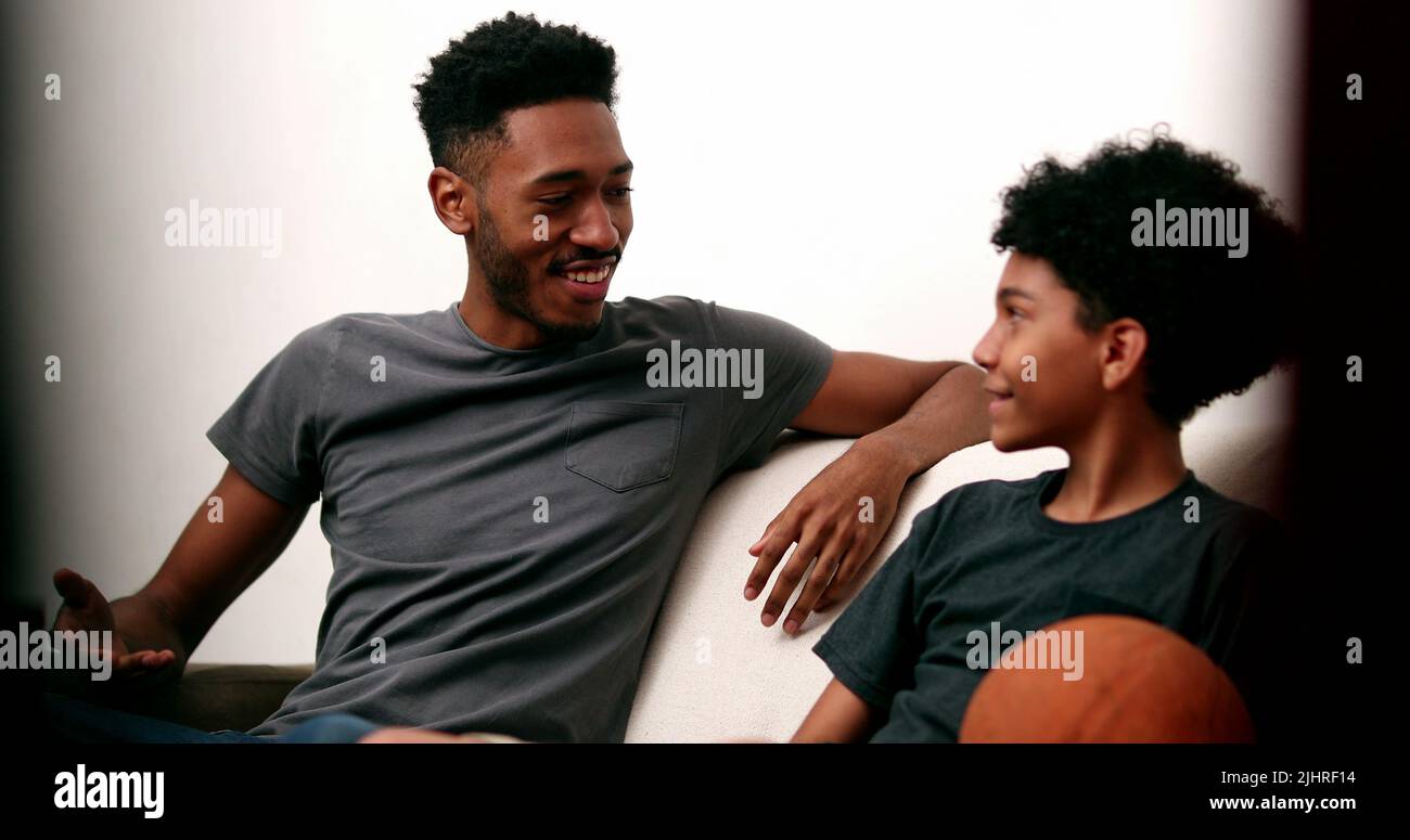Older brother teaching younger sibling to spin basketball with finger