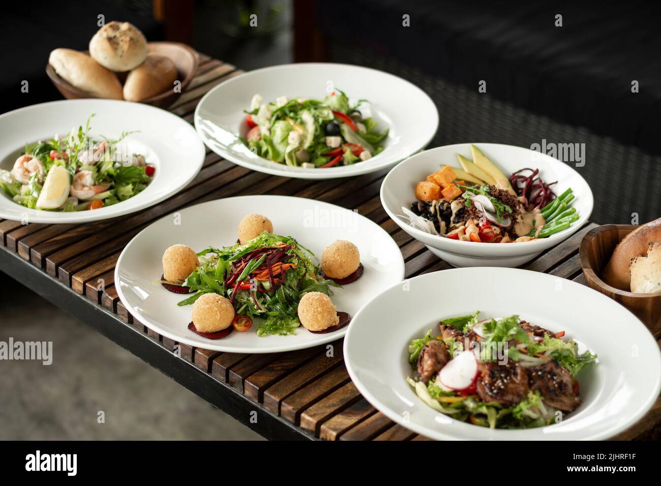 several different fresh mixed salad dishes on restaurant table Stock Photo