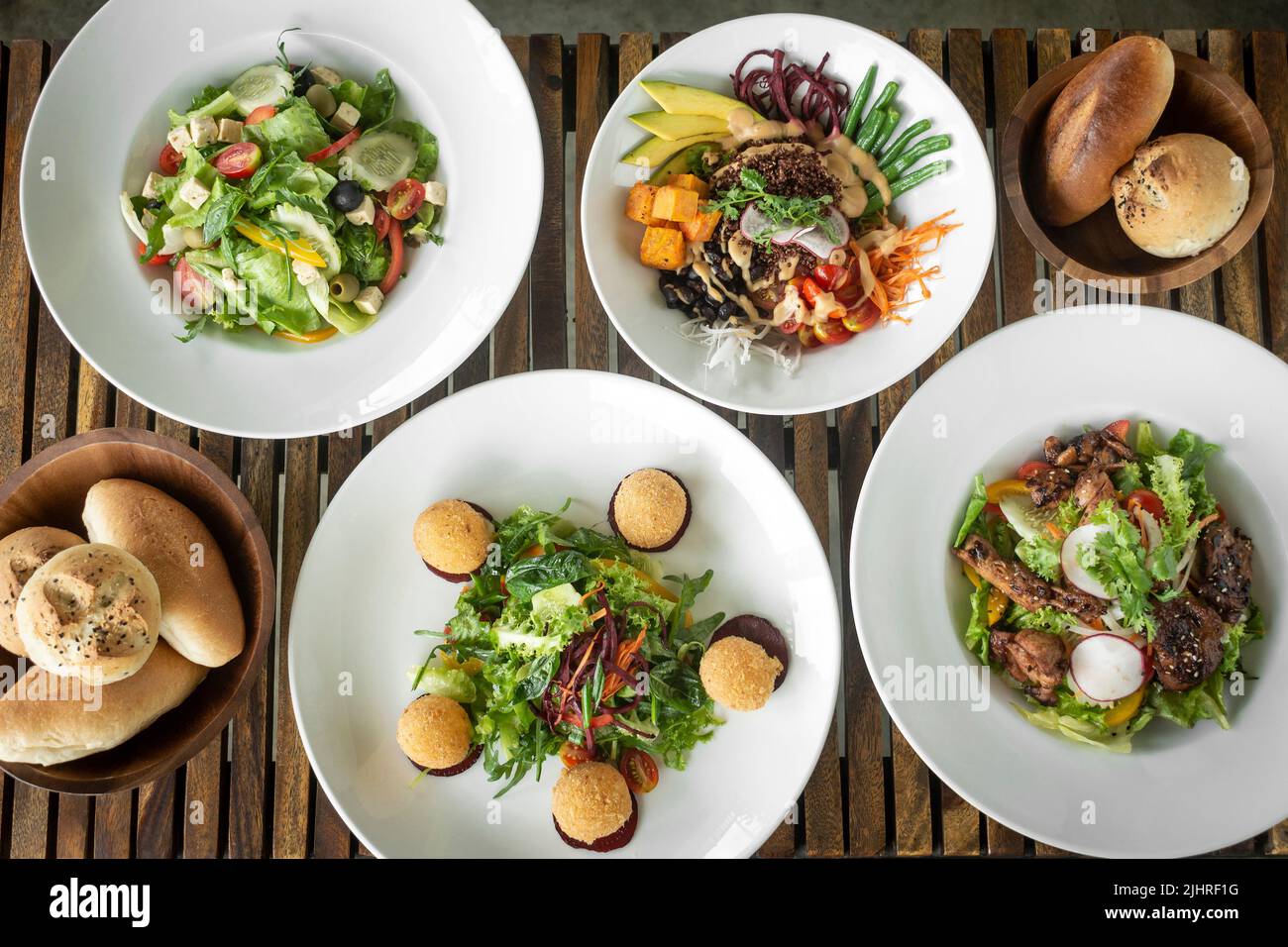 several different fresh mixed salad dishes on restaurant table Stock Photo