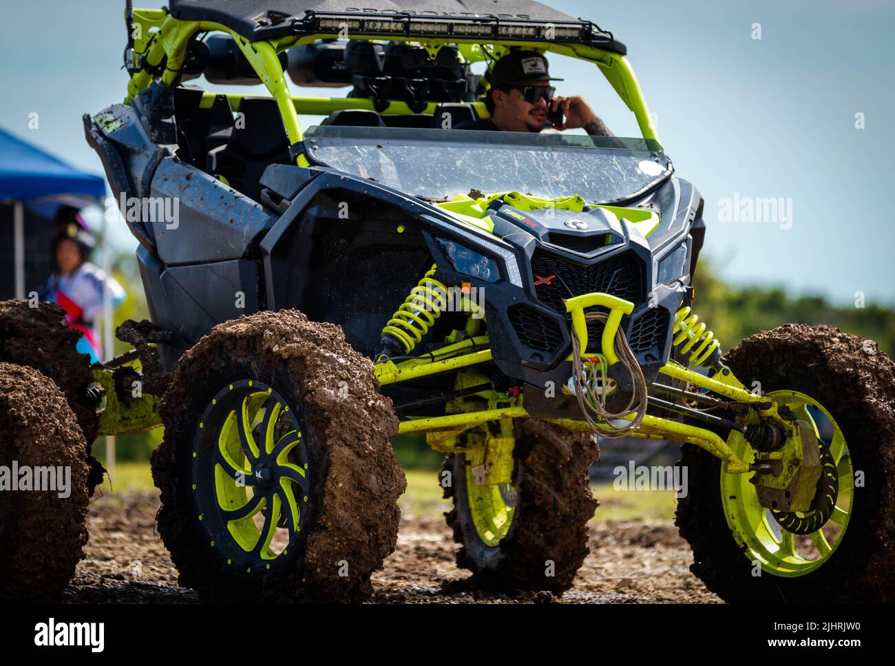 An ATV with people driving around and racing on a dirty muddy field at Rock Fest in 2020 Stock Photo