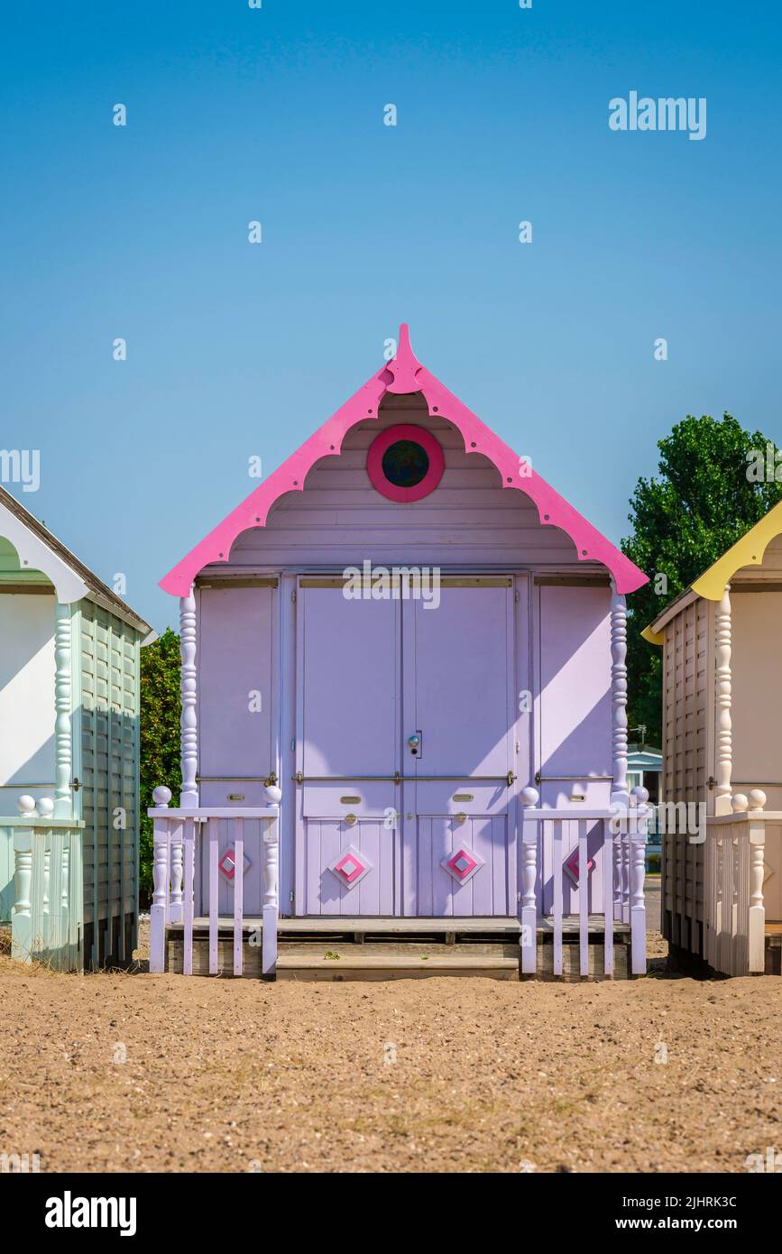 UK traditional summer holiday, view in summer of a colorful beach hut under a clear blue sky, West Mersea, Essex, England, UK Stock Photo