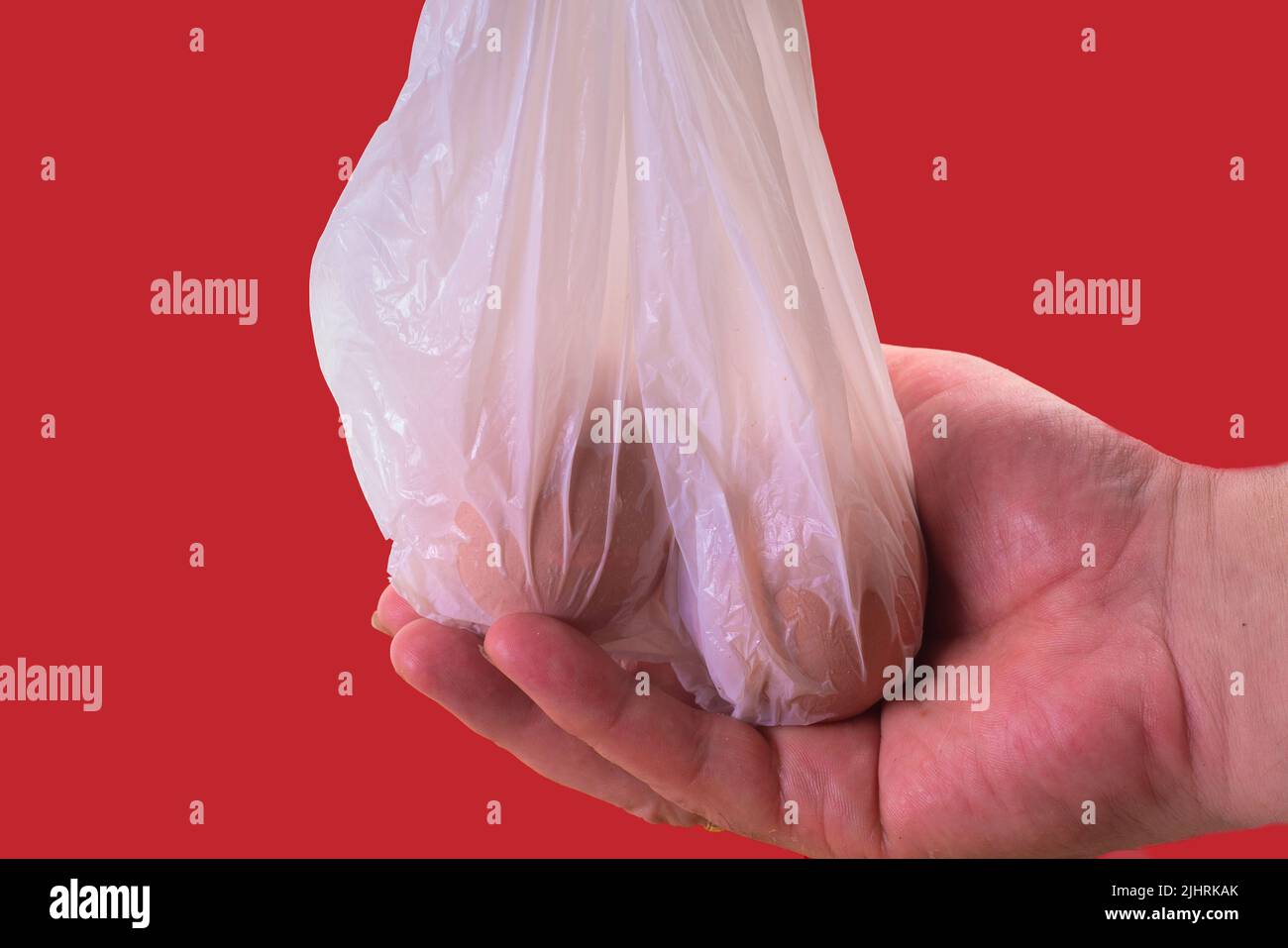 Hand Grasping A Bag With 2 Eggs. Symbol Photo For Examination And Palpation Of The Male Scrotum Stock Photo