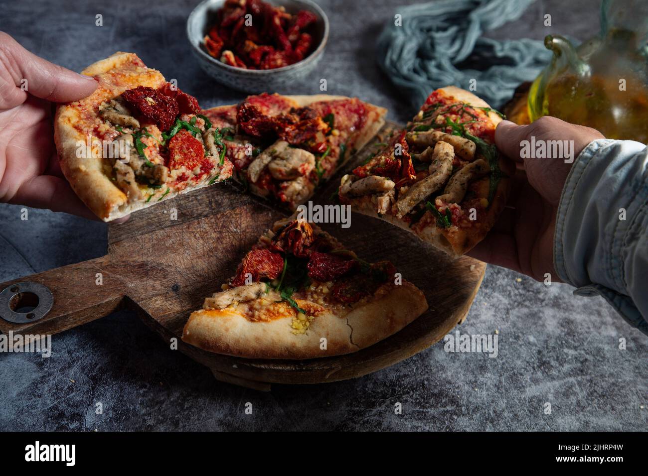 Diverse colleagues or friends take slices of vegan pizza and enjoy dinner. Stock Photo