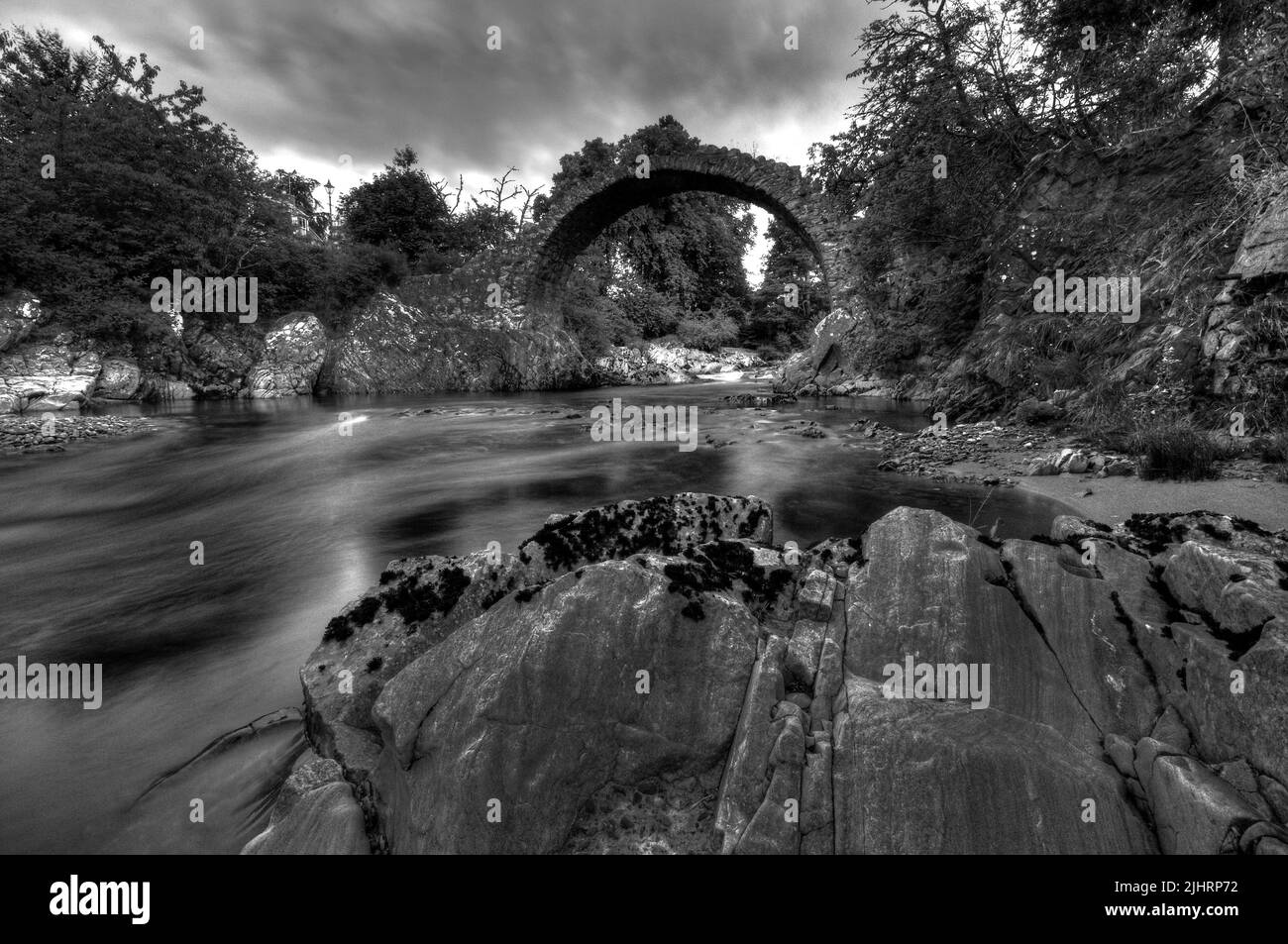 A grayscale shot of Old Pack Horse Bridge in Carrbridge town, Scotland Stock Photo