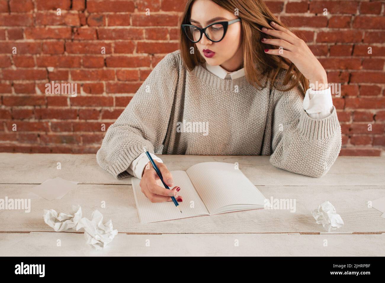 Surprised woman sitting at table with notebook Stock Photo
