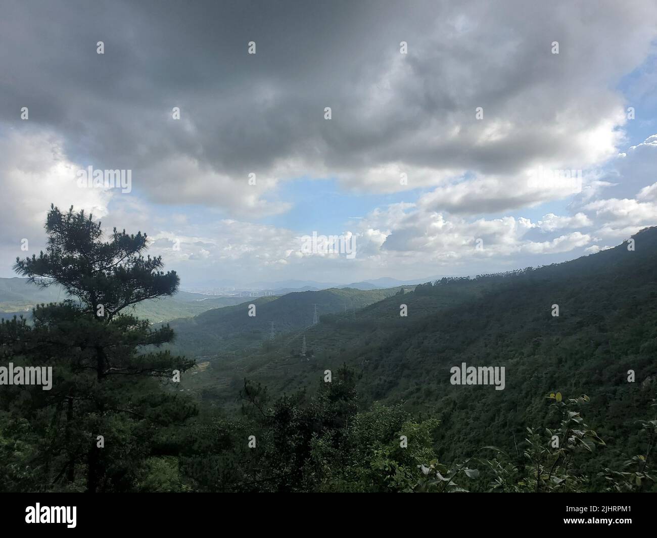 An aerial view of lush green mountain forests and valleys against dark ...
