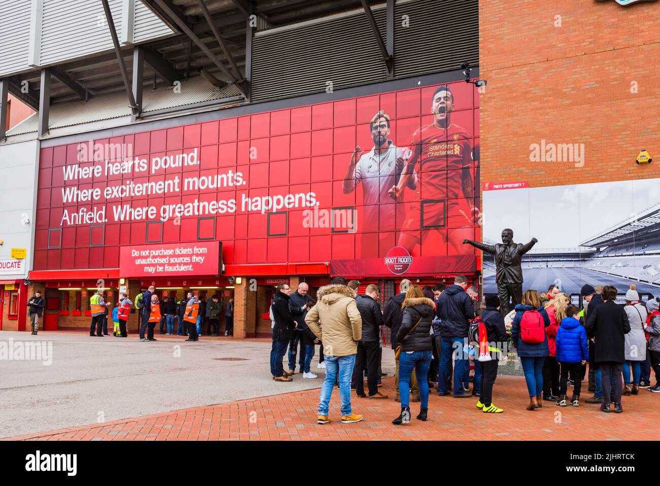 Liverpool F.C. supporters next to the Bill Shankly statue at Anfield Stadium. Anfield, Liverpool, Merseyside, Lancashire, England, United Kingdom Stock Photo