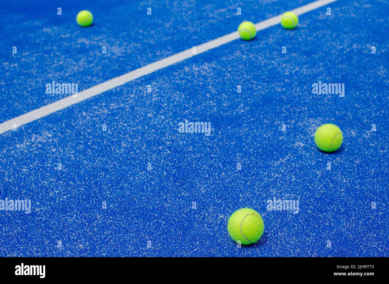 racket sports, five balls on the lines of a blue paddle tennis court Stock Photo Alamy