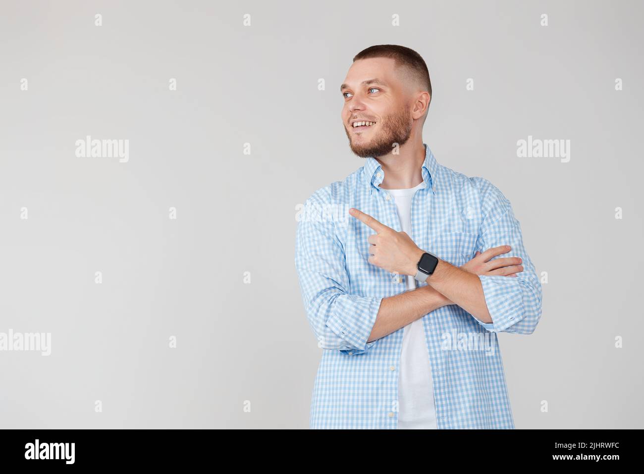 Young handsome bearded man pointing to the side Stock Photo