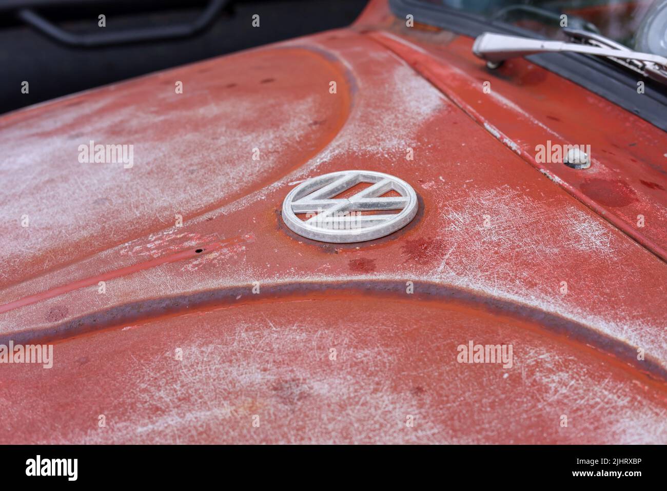 A closeup of a Volkswagen badge on a rusty hood of a car Stock Photo