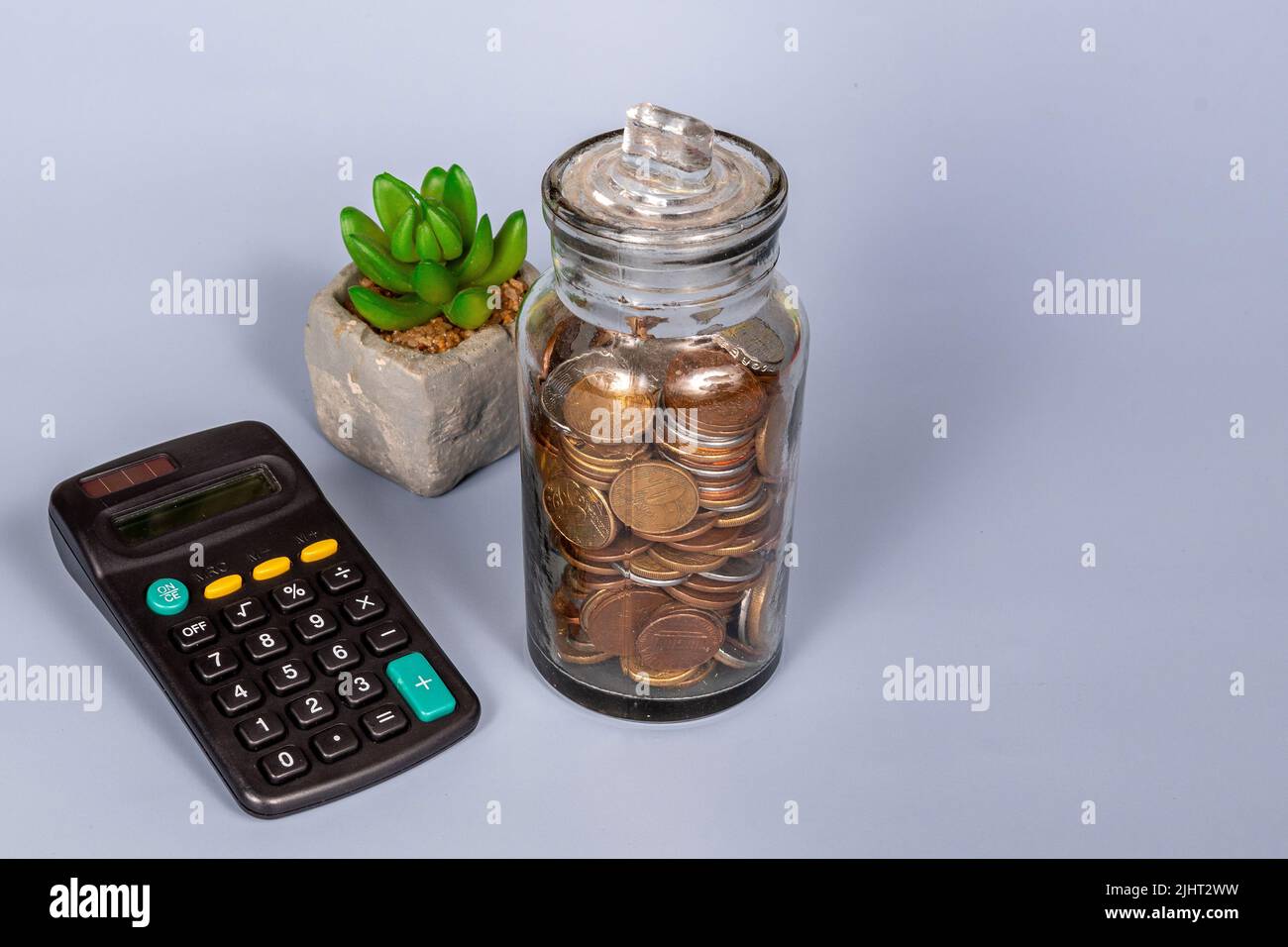 Money, financial, business growth concept, coins in glass jar with  calculator in blue background Stock Photo - Alamy
