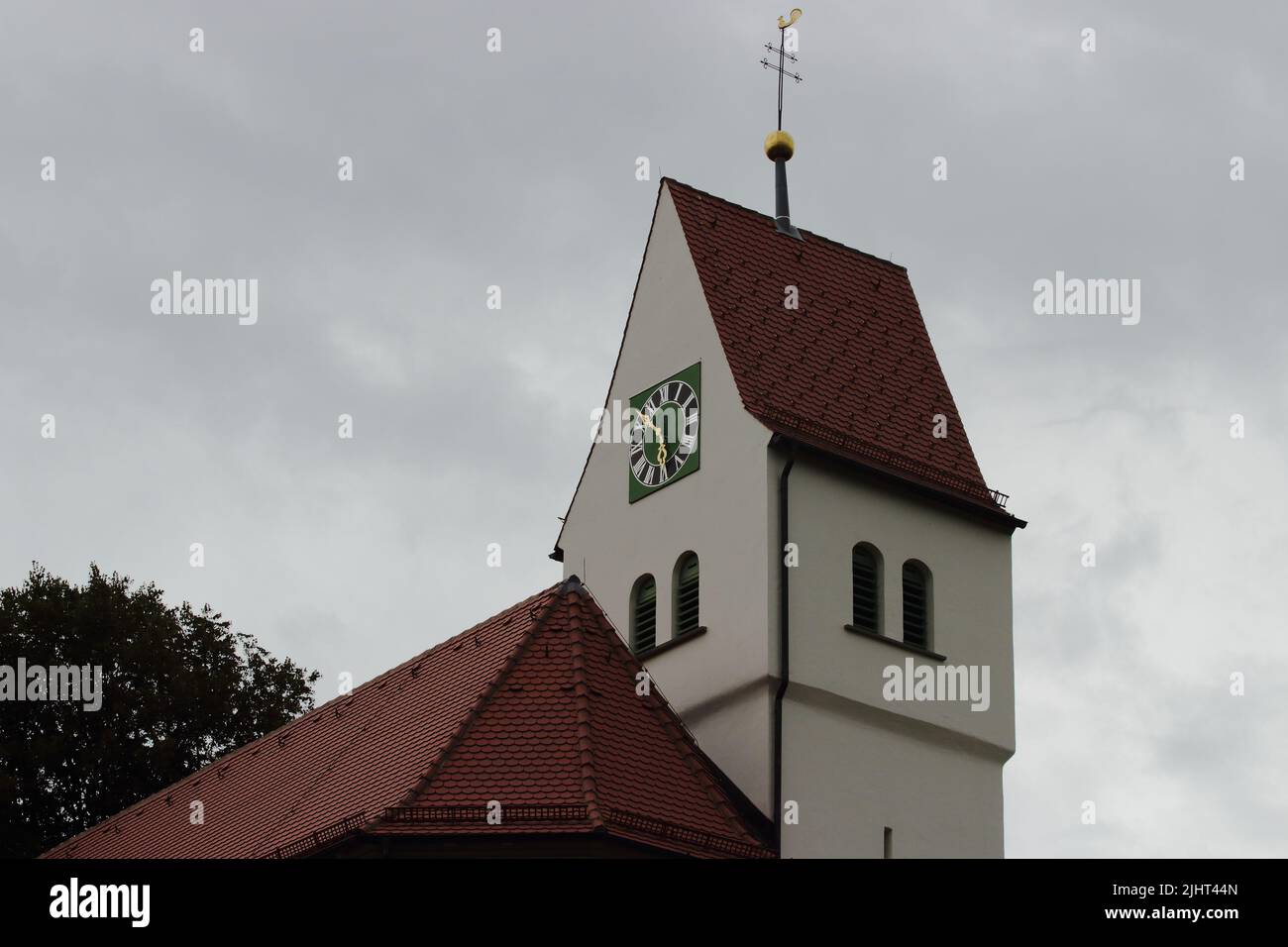 A low-angle shot of a church clock tower on a gloomy weather Stock ...