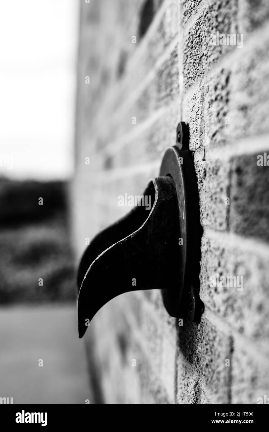 Brass metal down spout termination on the side of a brick building Stock Photo