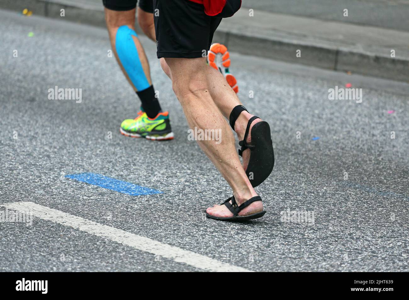 marathon runner in sandals on asphalt Stock Photo