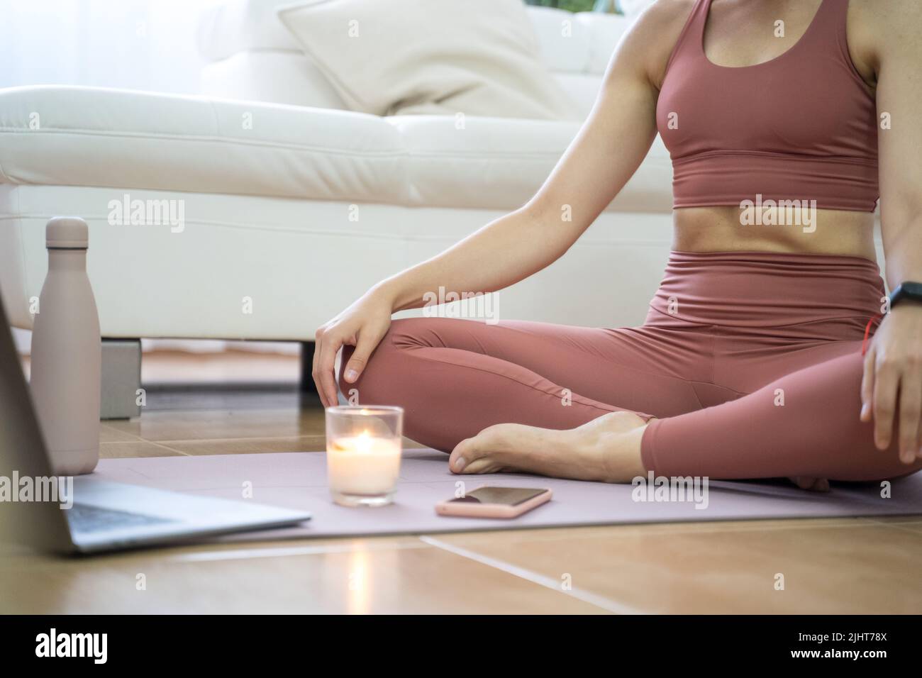 YOUNG GIRL DOING YOGA AND PILATES IN THE LIVING ROOM OF HER HOME WITH ...