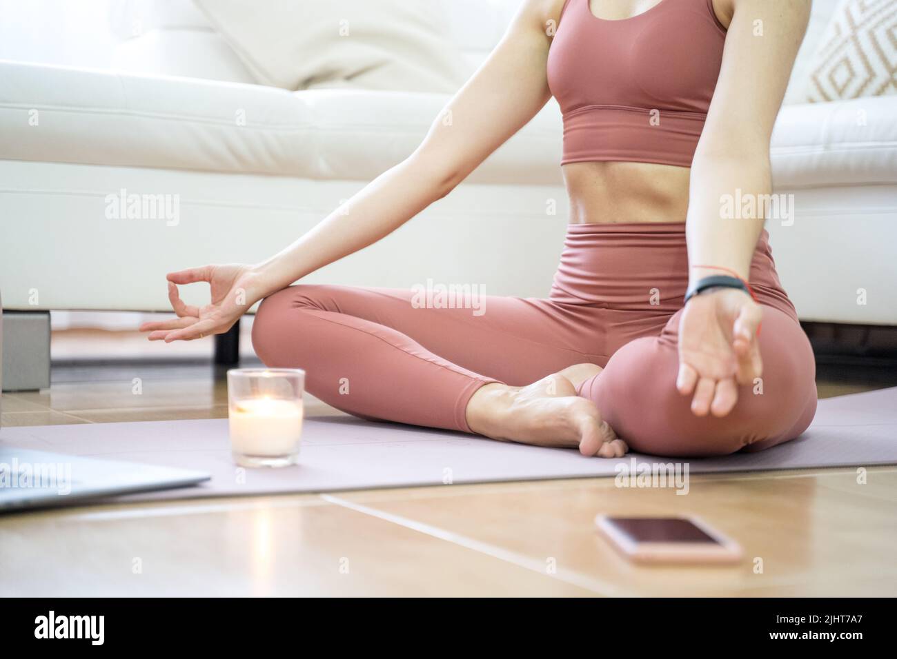 YOUNG GIRL DOING YOGA AND PILATES IN THE LIVING ROOM OF HER HOME WITH ...