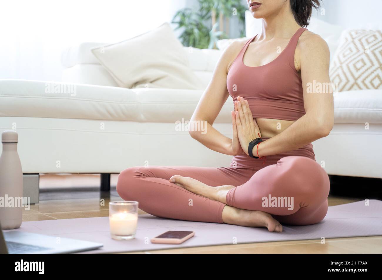 YOUNG GIRL DOING YOGA AND PILATES IN THE LIVING ROOM OF HER HOME WITH ...