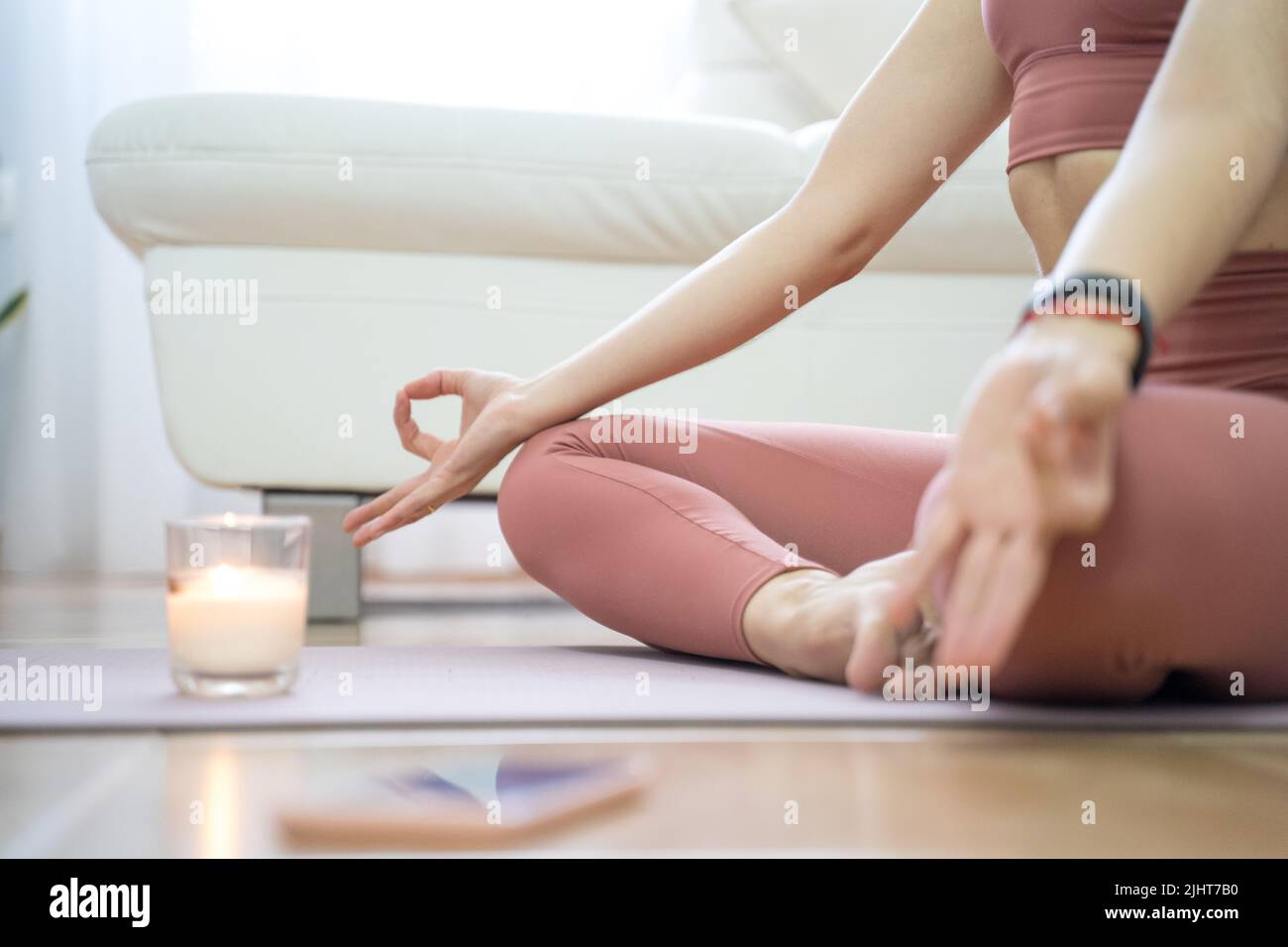 YOUNG GIRL DOING YOGA AND PILATES IN THE LIVING ROOM OF HER HOME WITH ...
