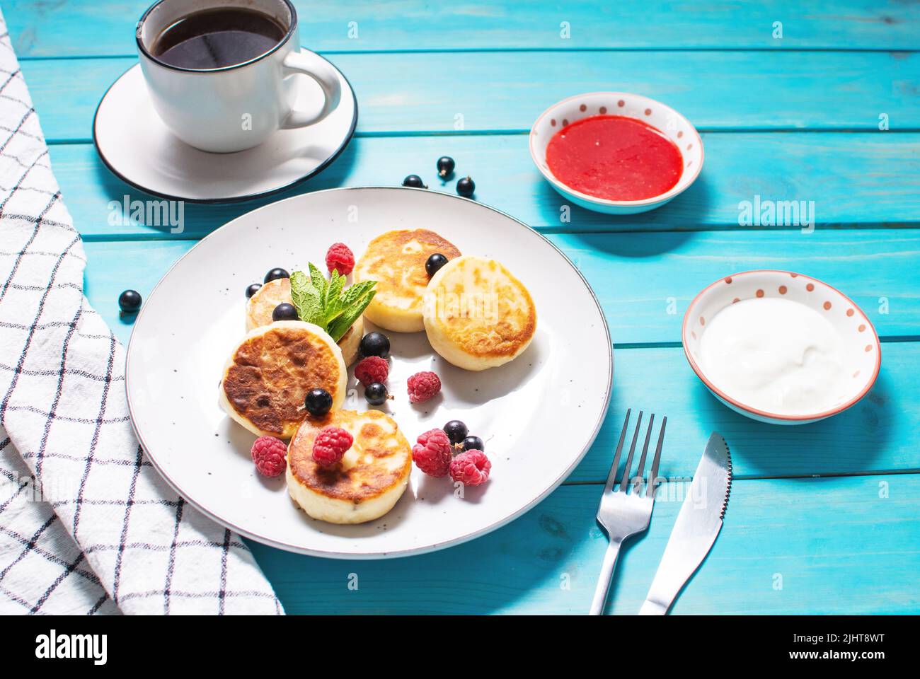 Cottage cheese pancakes, ricotta fritters or syrniki with currant and raspberry. Healthy and delicious morning breakfast. Stock Photo