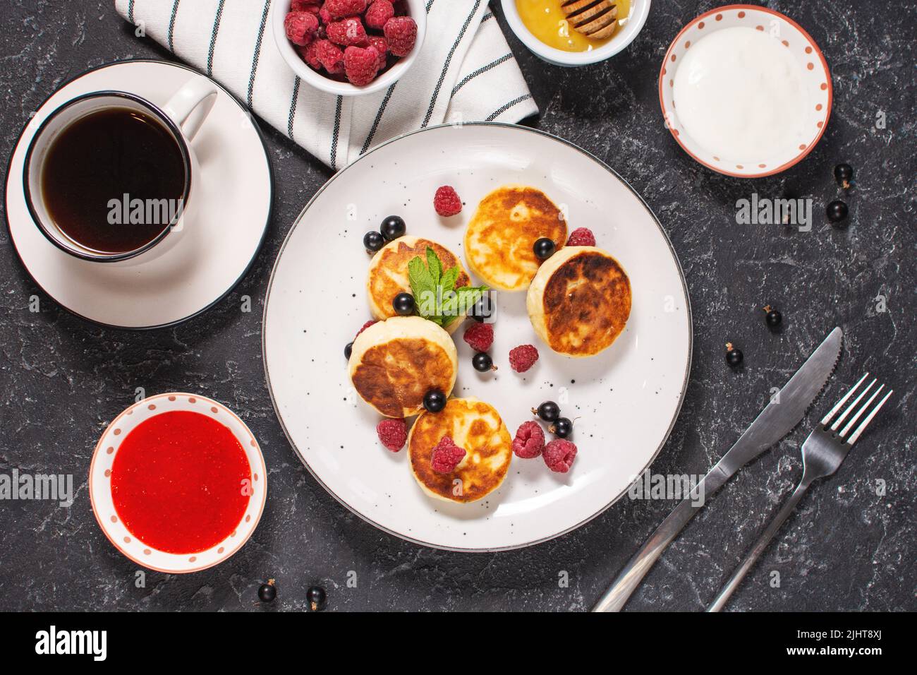 Cottage cheese pancakes, ricotta fritters or syrniki with currant and strawberries. Healthy and delicious morning breakfast. Top view Stock Photo