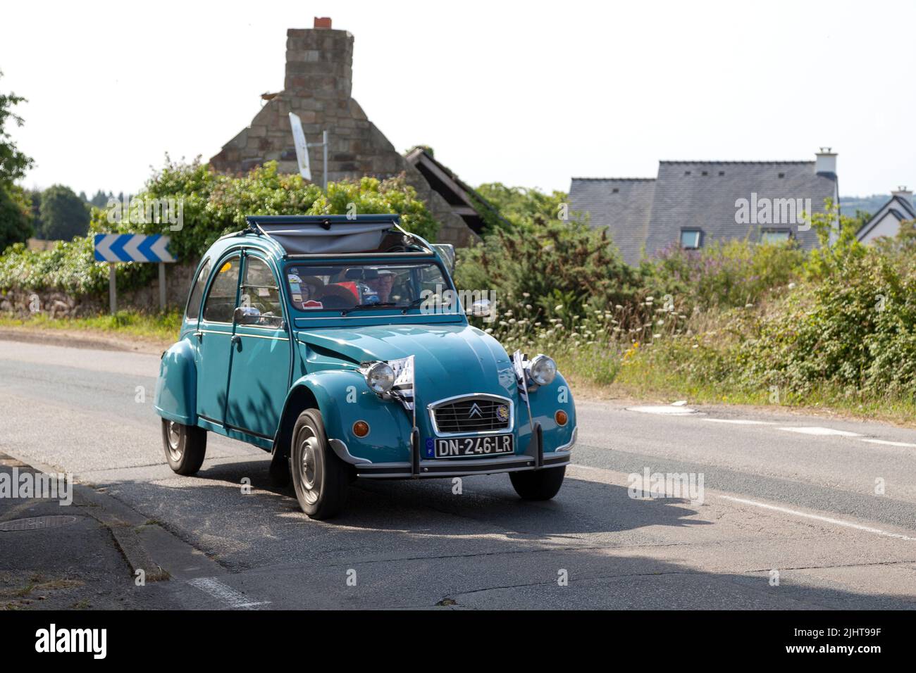 Kerlaz, France - July 17 2022: Retired couple cruising in a green Citroën 2CV with two Breton flag in the front. Stock Photo