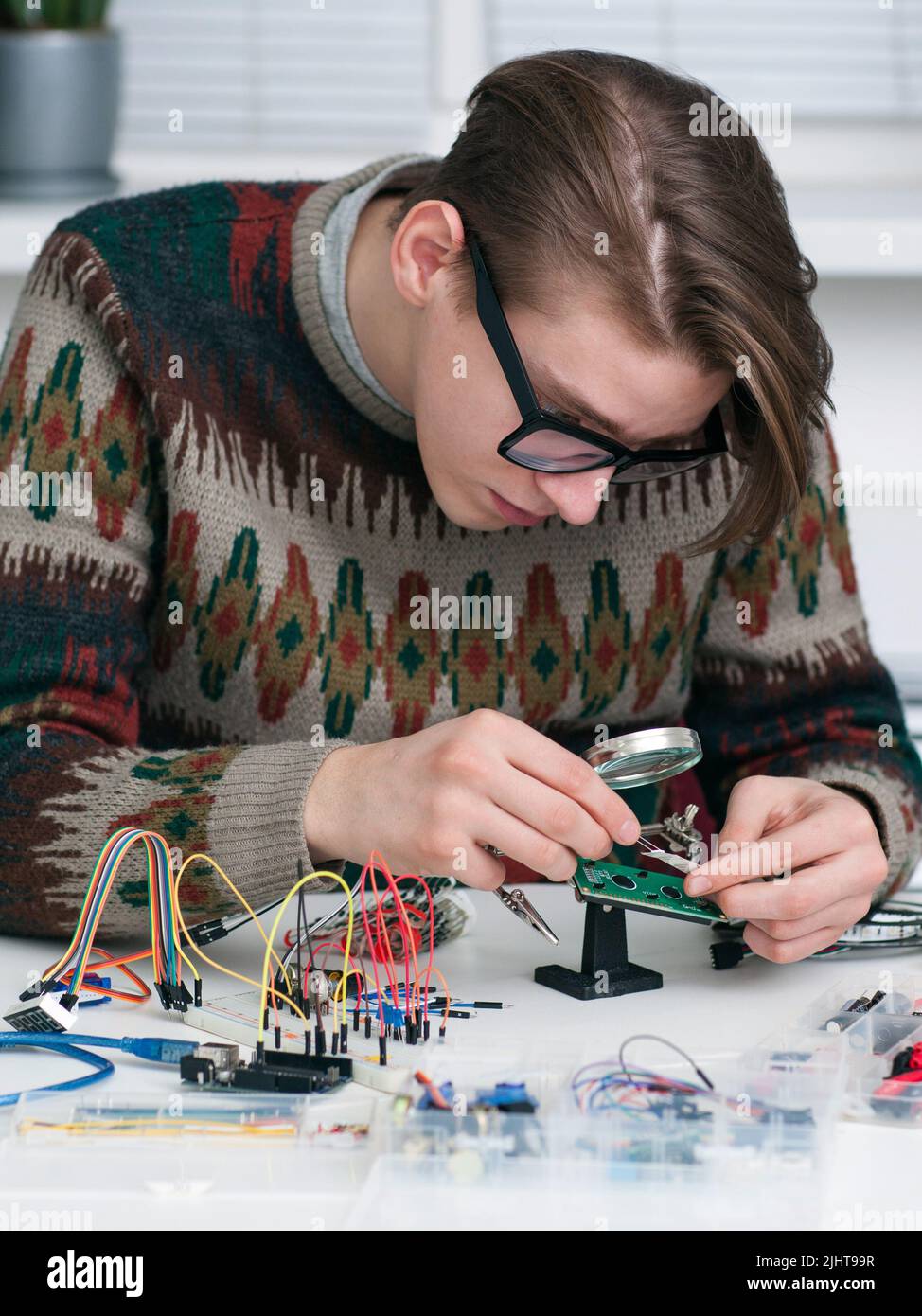 Young inventor examing electronic component Stock Photo