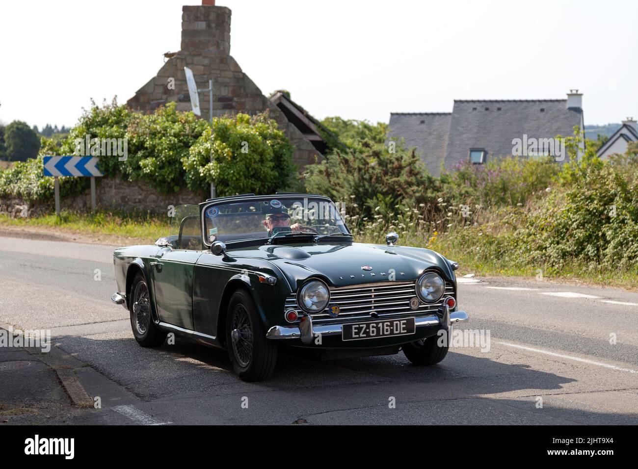 Kerlaz, France - July 17 2022: Retired couple cruising in a green Triumph TR5 sports convertible. Stock Photo