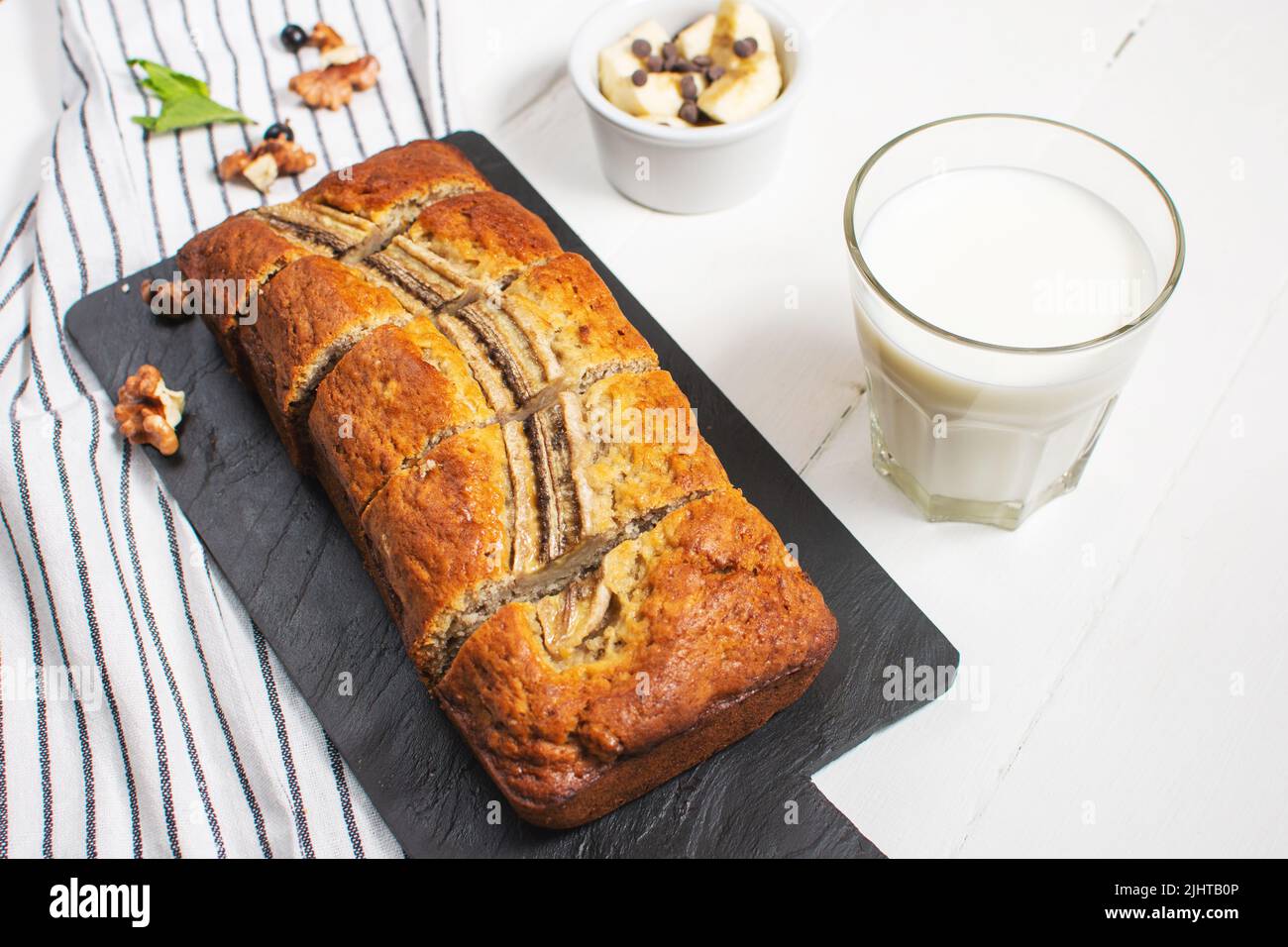 Banana bread or cake on white wooden table. Delicious homemade dessert, tasty snack or morning breakfast. Stock Photo