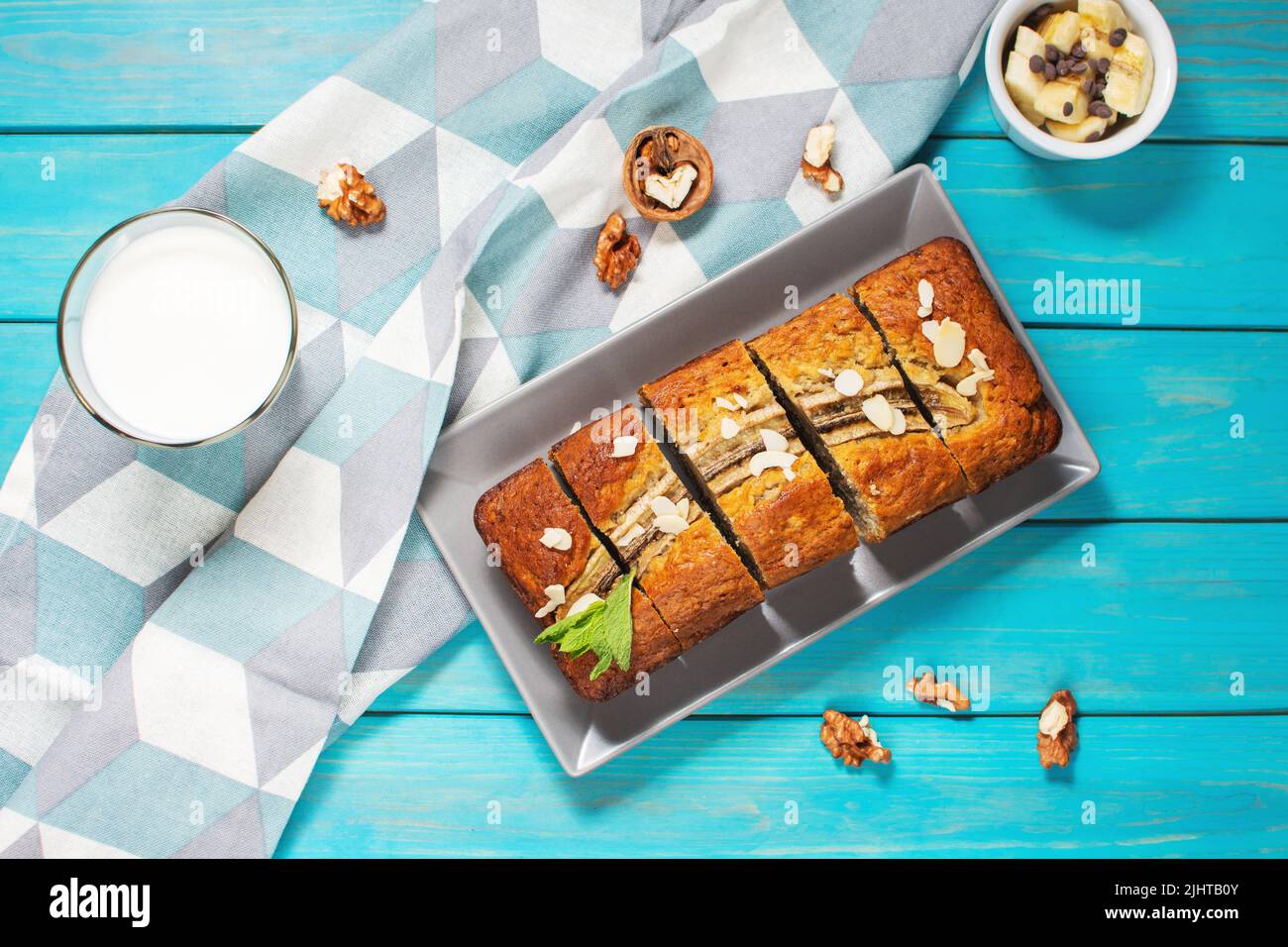 Banana bread or cake on blue wooden table. Delicious homemade dessert, tasty snack or morning breakfast. Top view Stock Photo