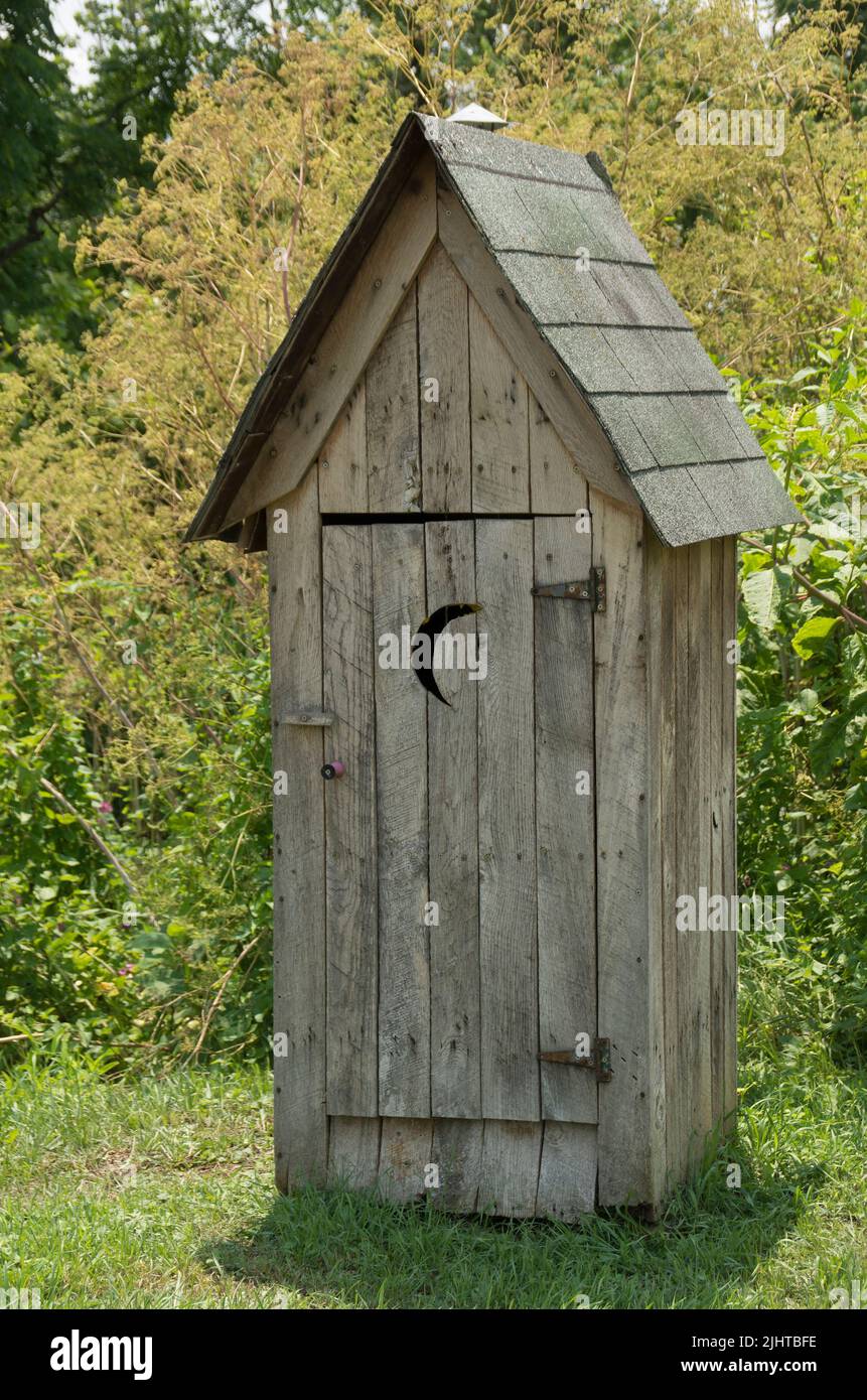 A vertical shot of an oldfashioned outhouse ready for use Stock Photo