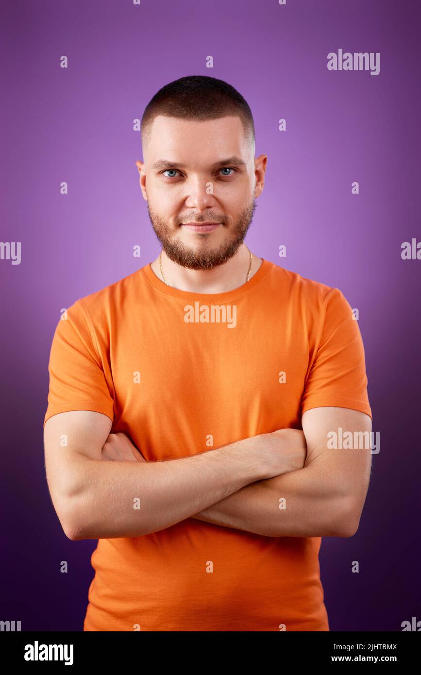 smiling young guy posing with crossed arms Stock Photo