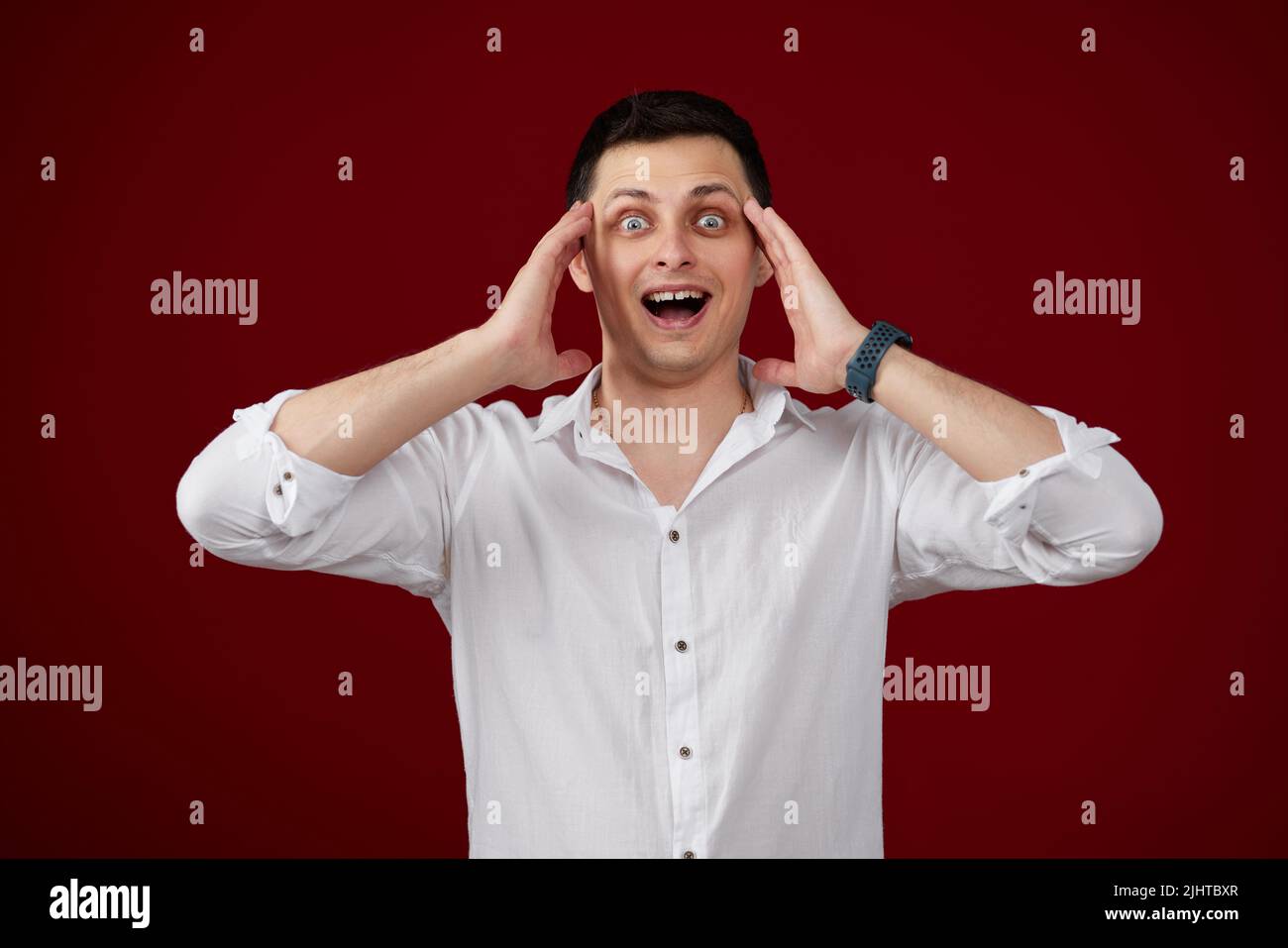 surprised young brunette man in white shirt Stock Photo