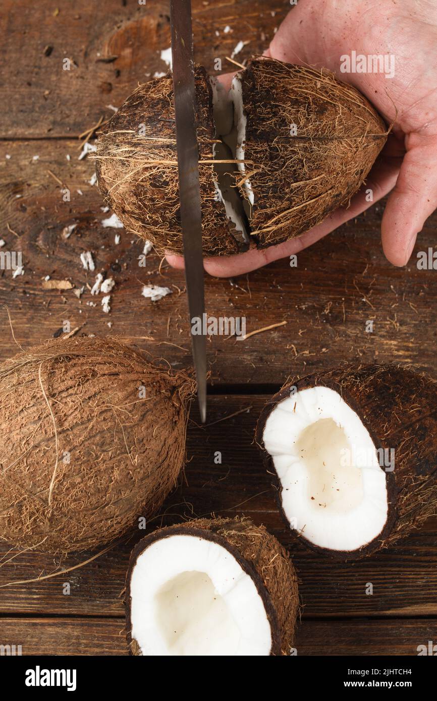 Coconuts cut on brown wooden background Stock Photo