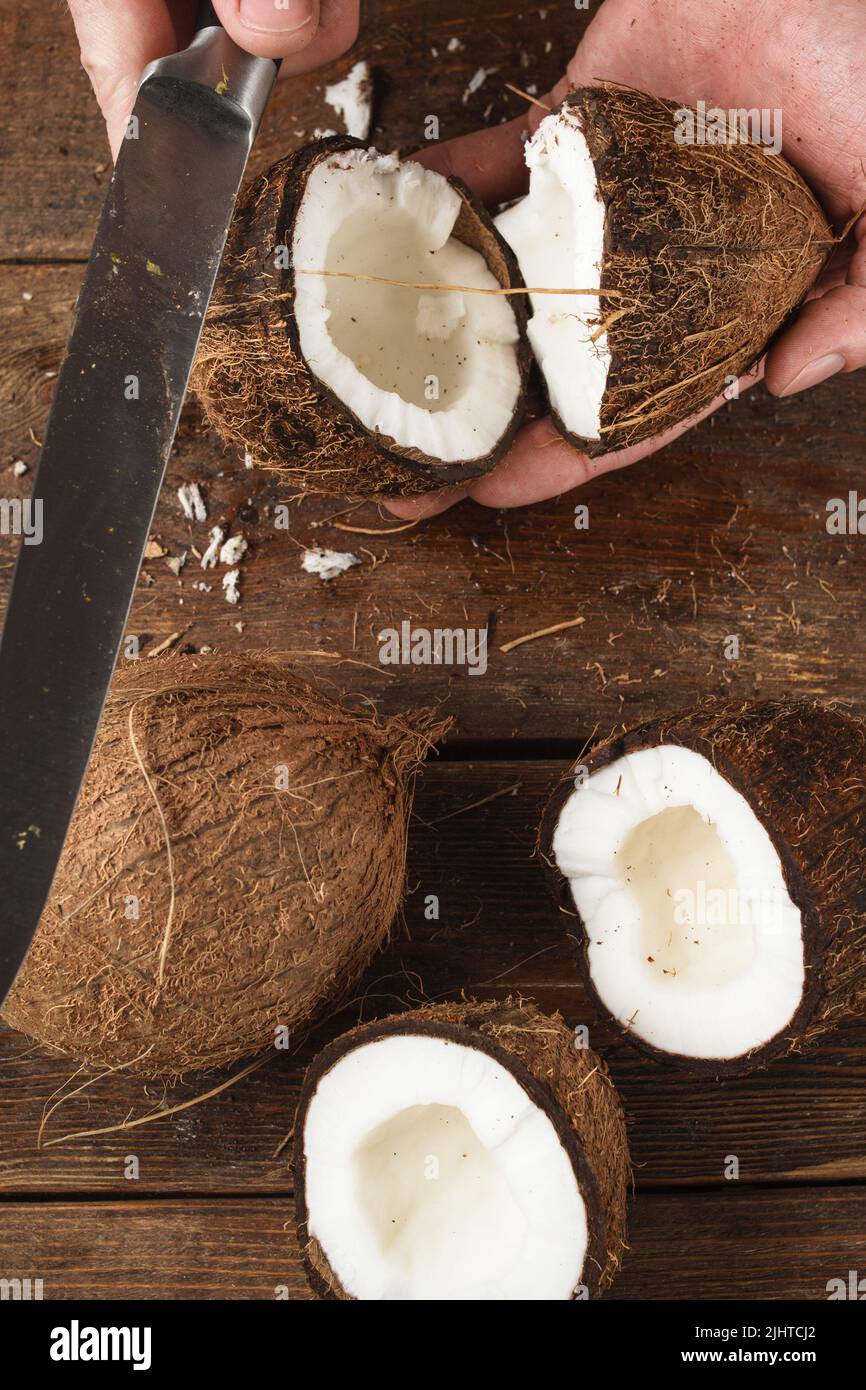 Coconut broken by knife on wooden background Stock Photo