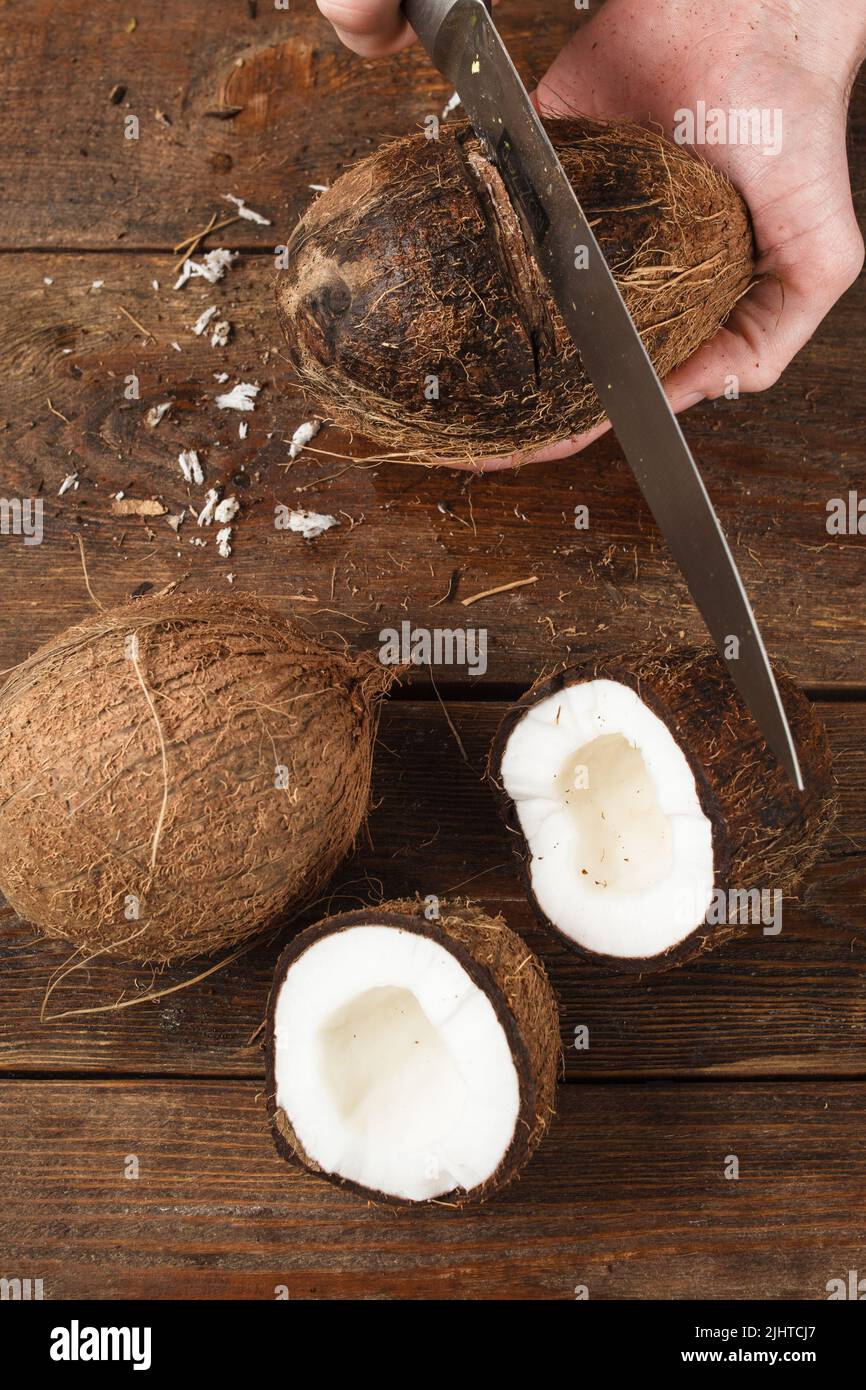 Coconuts cut on brown wooden background Stock Photo